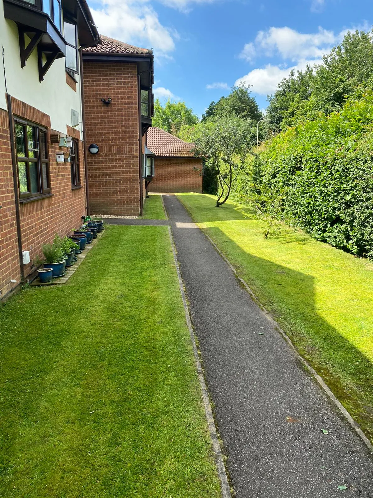 A paved pathway between two brick buildings.