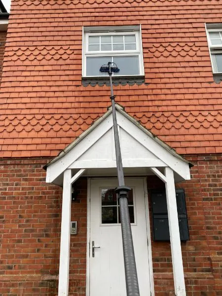 A white door and a red brick building.